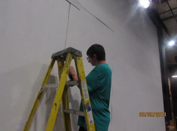 Trevor Veer works on the Mean Girls set during a tech theater class