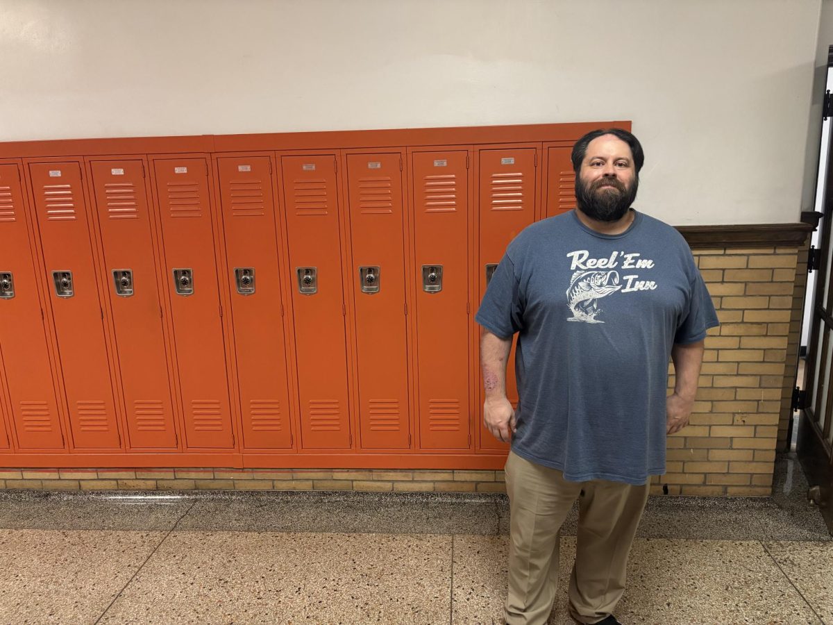 Mr. Fischer poses for a picture outside his classroom