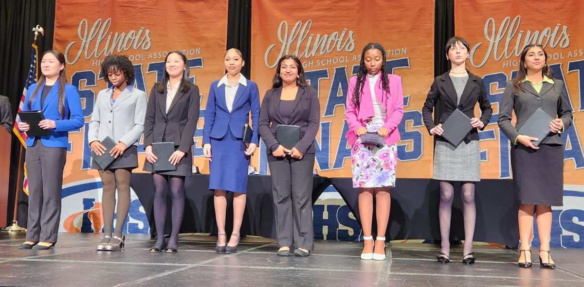 Mya Ortiz (far right) waits to hear how she placed in the state final round of Poetry during the IHSA State Speech Finals