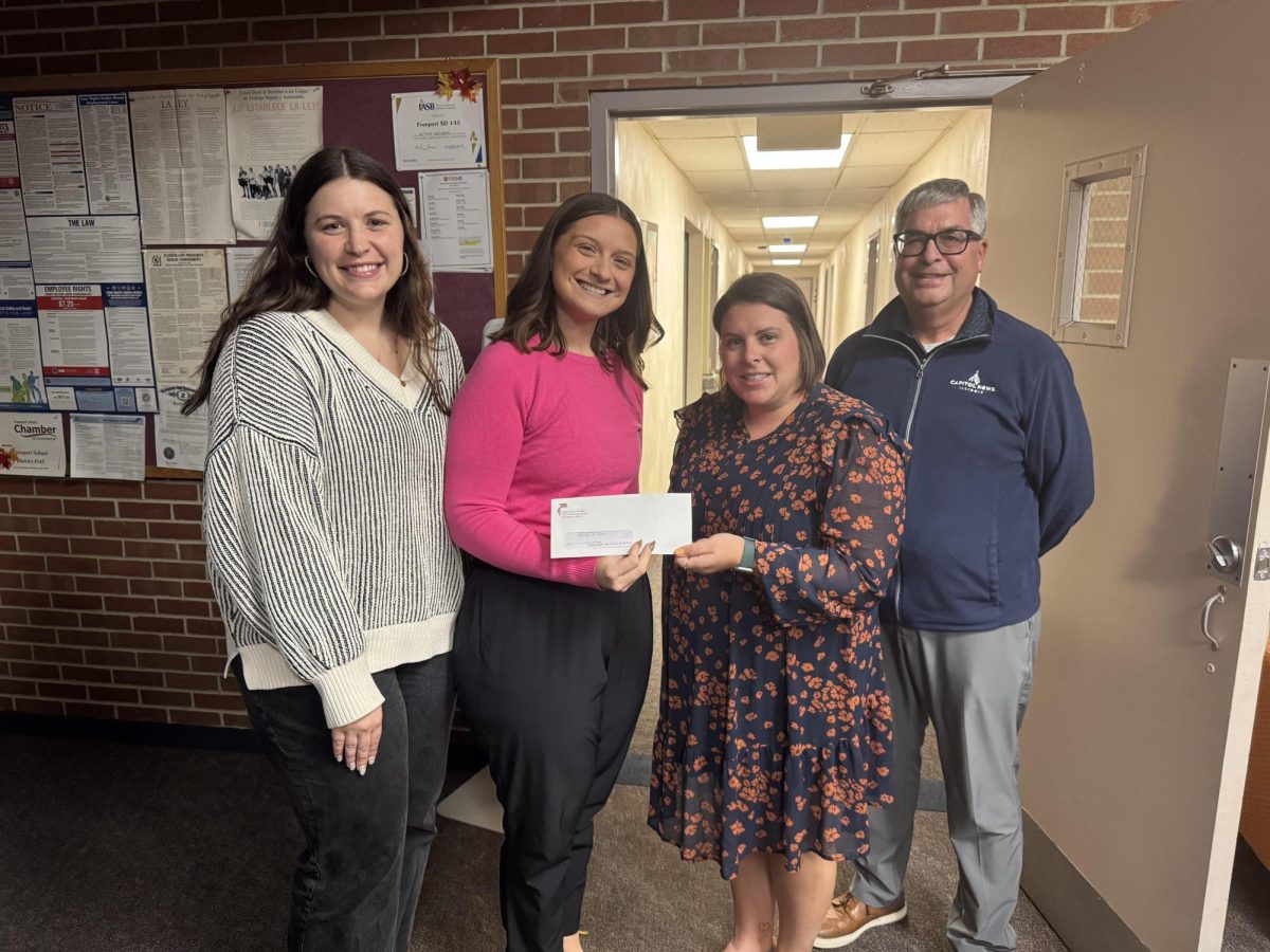 Haley Kurtz and Jena Kleindl receive a grant from Victoria Hansen with the Stephenson County Farm Bureau and Jeff Rogers with the Illinois Press Foundation at the Oct. 21 FSD145 Board Meeting
